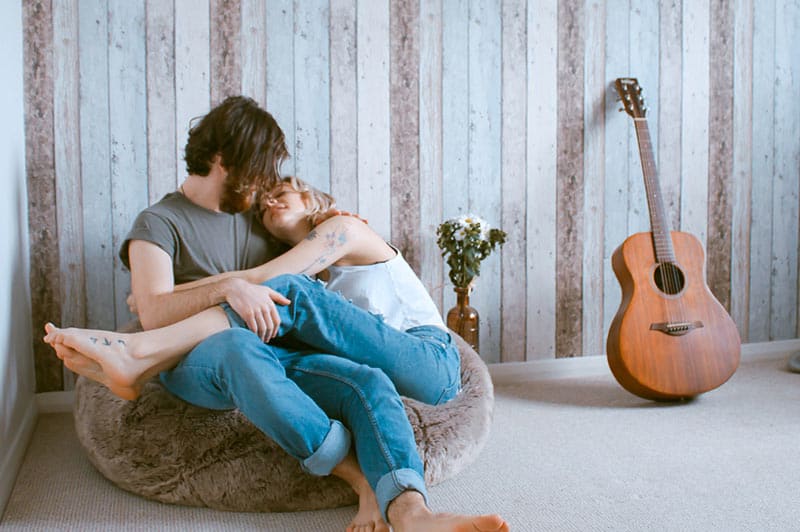 Couple seated on beanbag snuggling