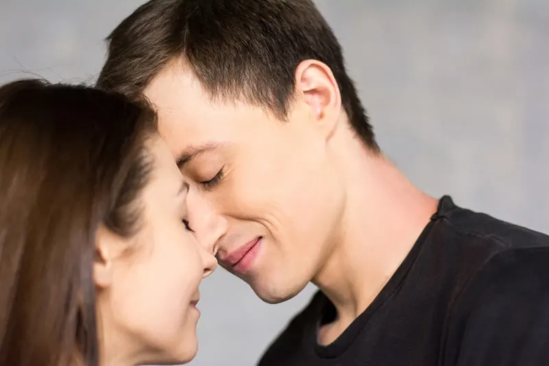 Smiling couple touching foreheads with eyes closed