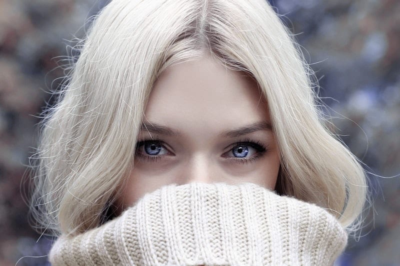 woman covering face with jumper