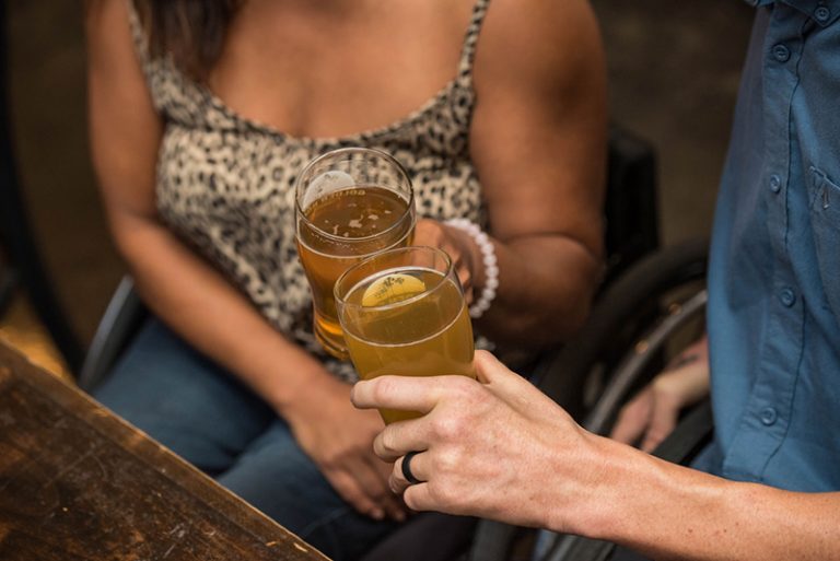 man and woman holding drinking glasses and toasting