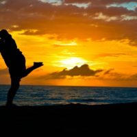 uomo e donna in piedi sulla riva del mare che si baciano