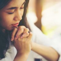 joven asiática rezando
