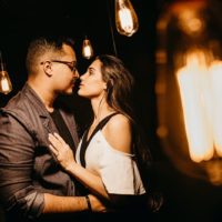 man and woman looking at each other surrounded with light bulbs