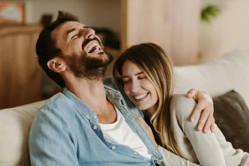 Happy young couple laughing while talking about something