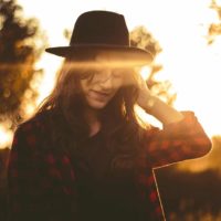 cute woman wearing hat on sunset