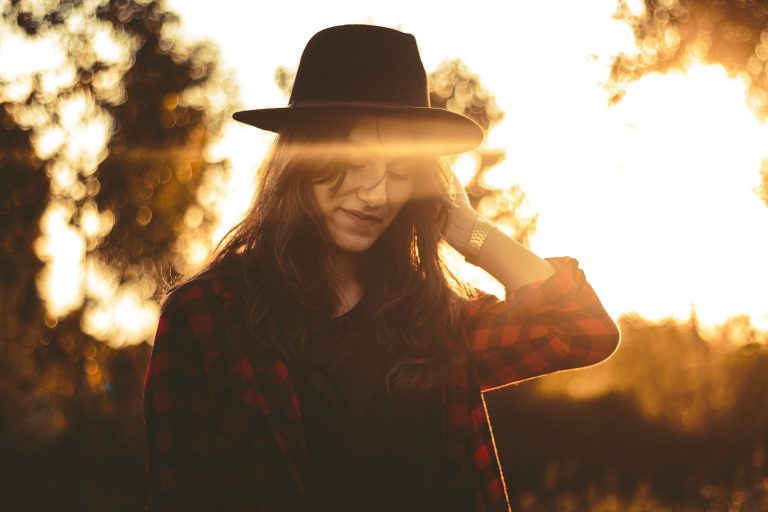 cute woman wearing hat on sunset