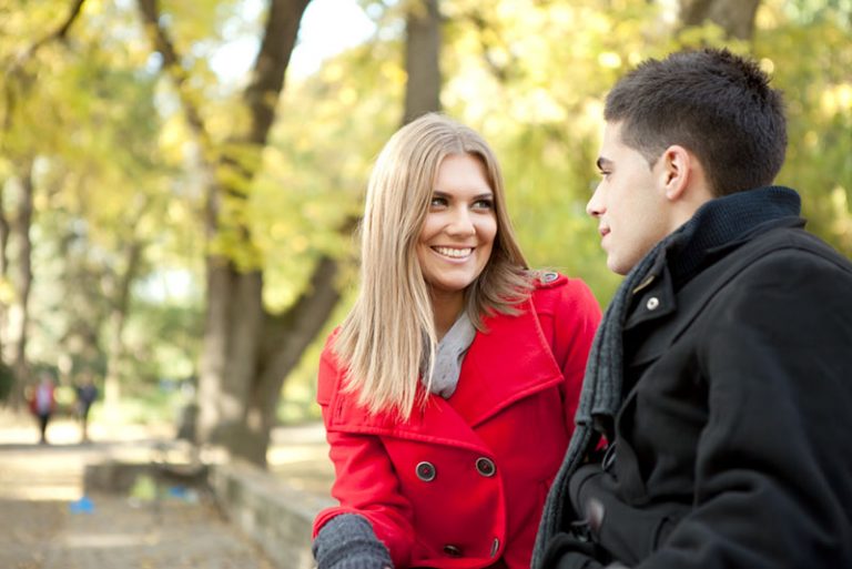 smiling blond woman talking to man
