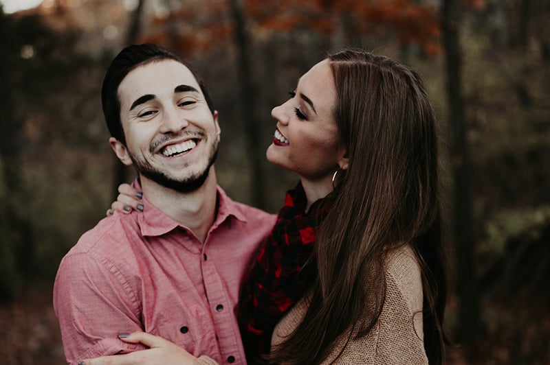 Laughing couple huggin outdoors in autumn