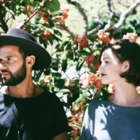 man and woman standing beside flowers