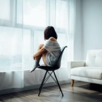 woman sitting on black chair in front of window