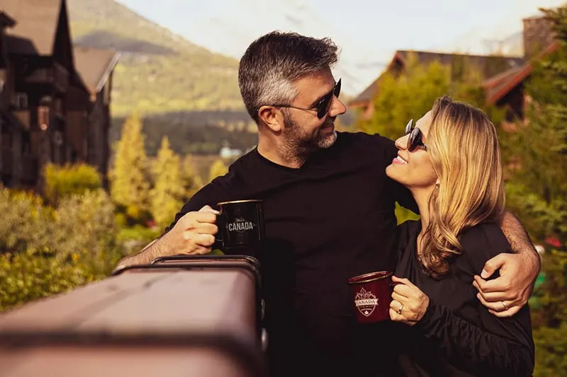 Couple having coffee with man hugging woman 