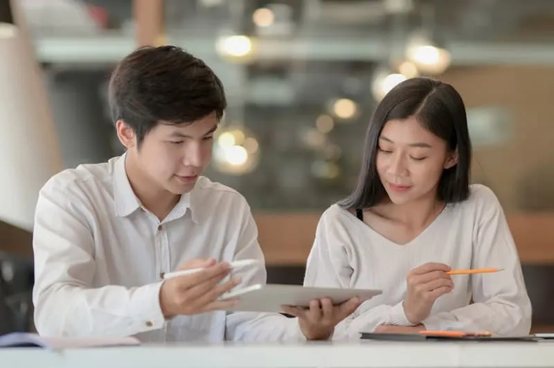Man discusses plan with woman using a tablet