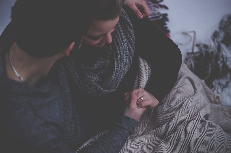 Coppia di sposi che si tiene per mano con una coperta che copre i fianchi