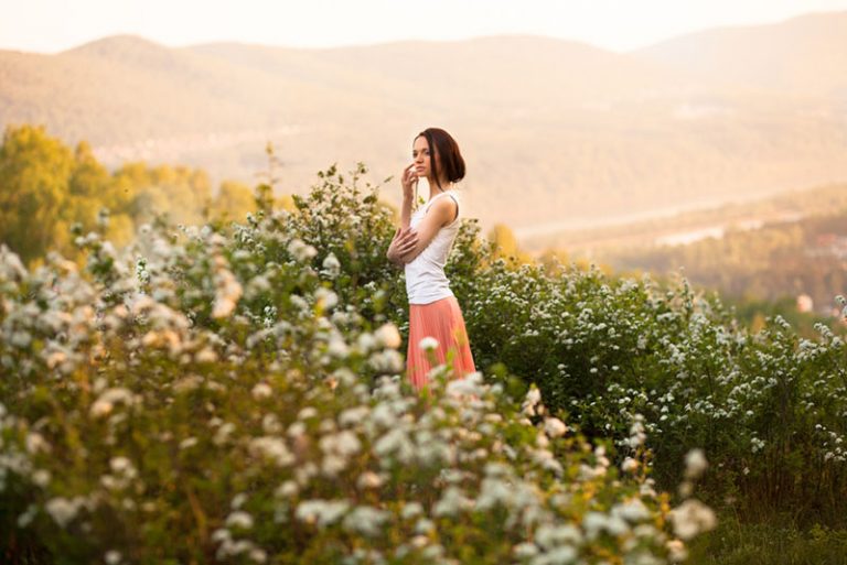 calm woman walking through flower field