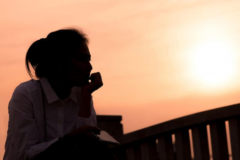 sad woman sitting in the sunset