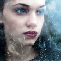 sad woman looking through iced window