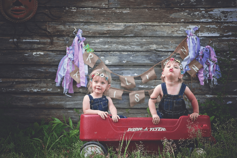 female twins standing in wagon outdoor