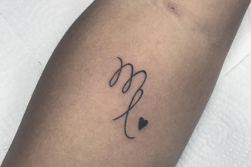 Virgo sign tattoo with a small heart on the forearm