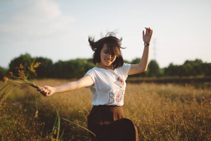 Woman holding flower on field