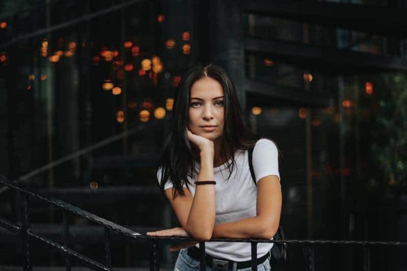 Woman leans on black handrail