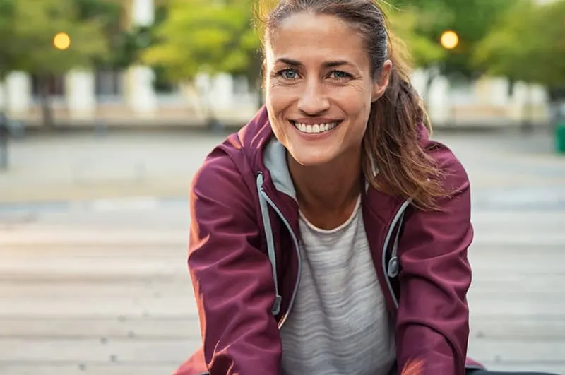 Smiling woman wearing a maroon sports jacket
