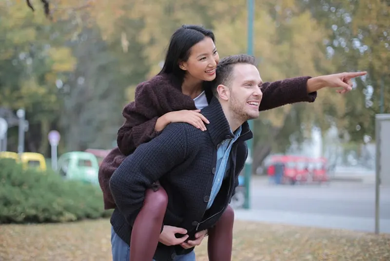 Woman piggyback on man at the park