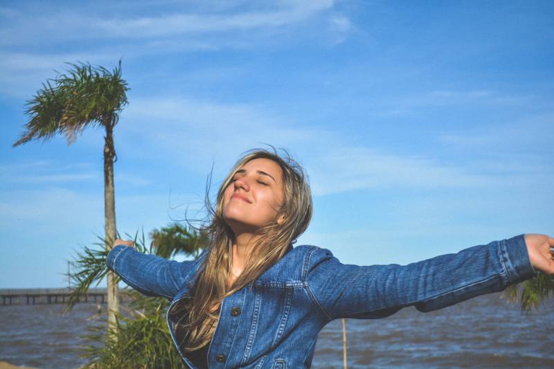 Mulher a abrir os braços no exterior