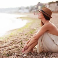 young mindful woman sitting on the sand