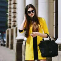 donna con cappotto giallo in piedi all'esterno