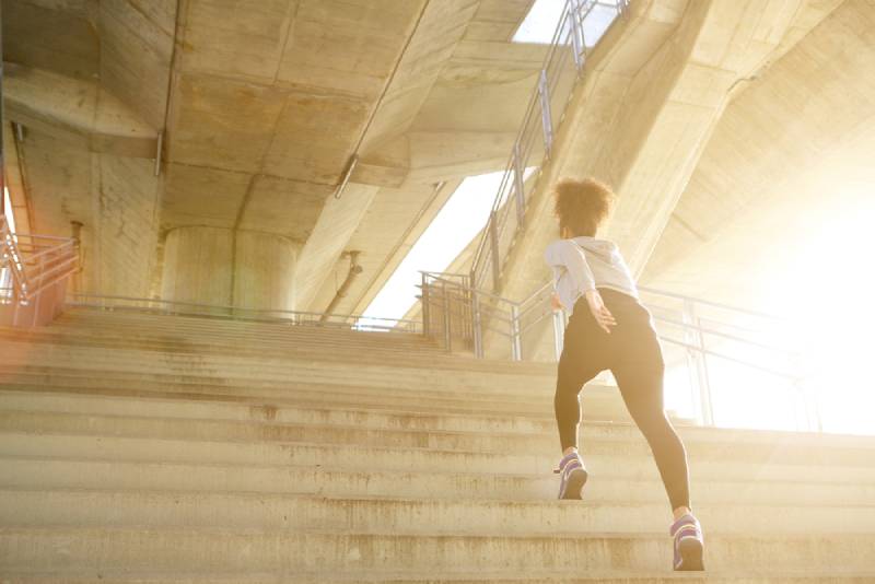 Ejercicios joven mujer corriendo sola escaleras arriba