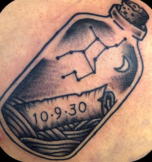 a message in a bottle tattoo with the date 