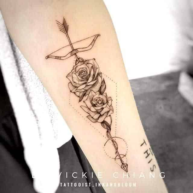 tatuaje de una flecha rosa en el brazo