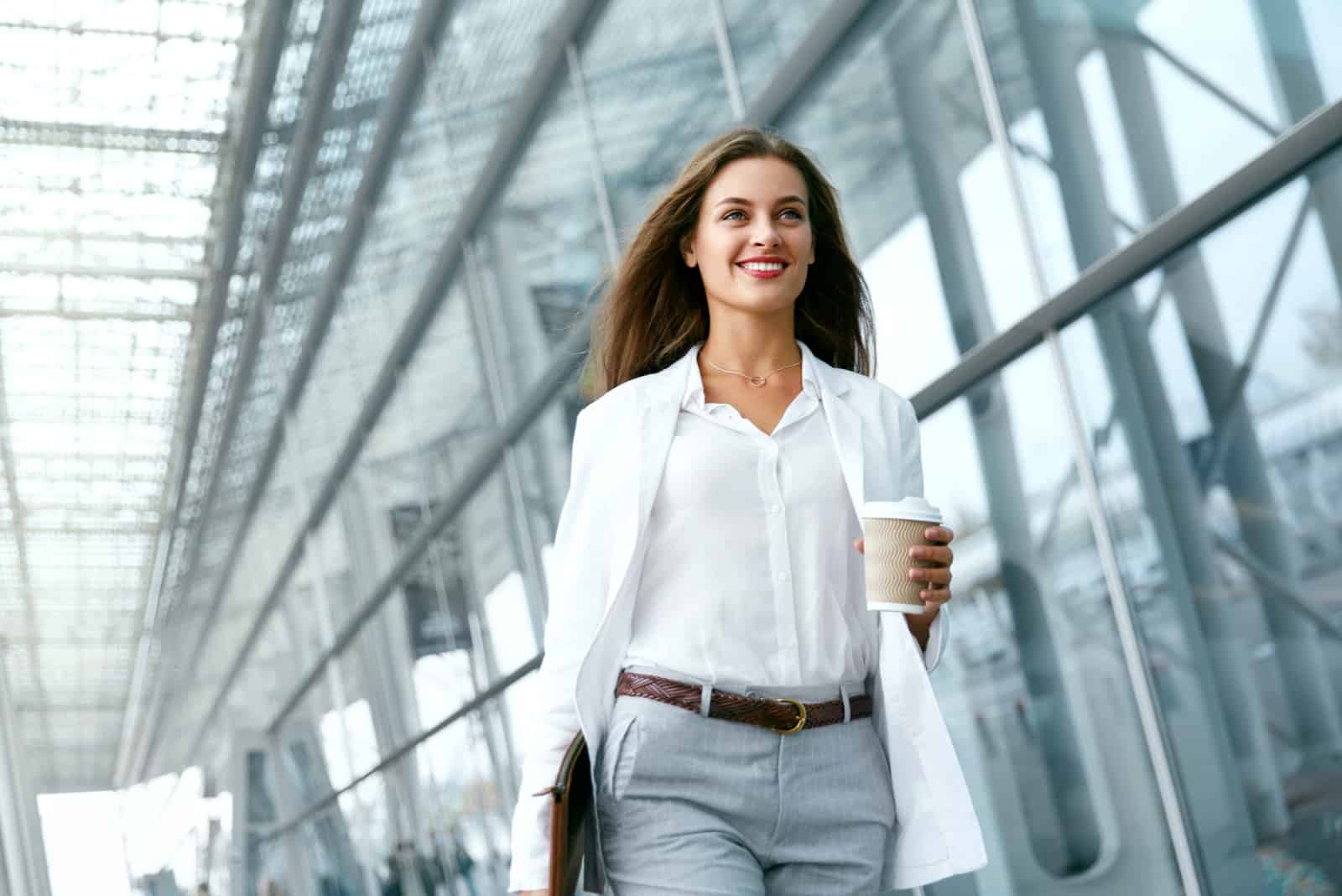 a smiling woman walks down the street