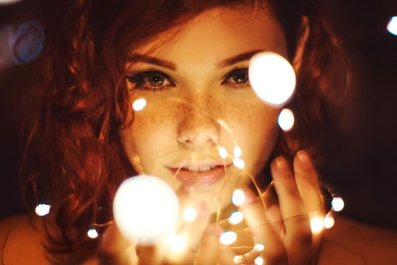 a woman's face focused holding series lights