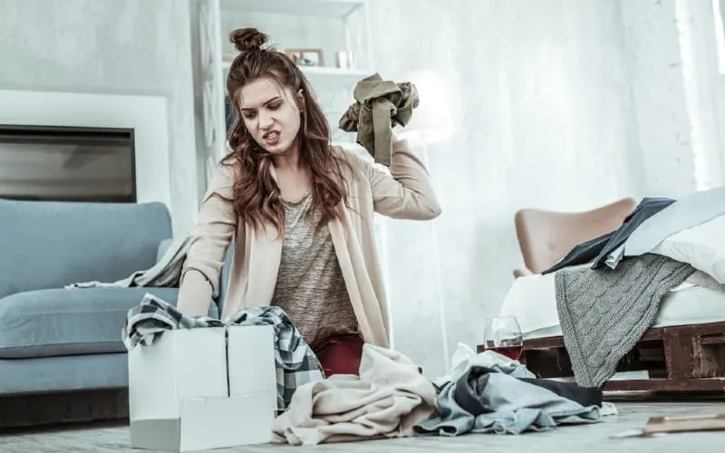 Angry young woman getting rid of her ex things