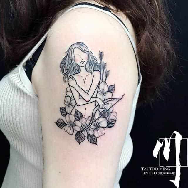 arquero rodeado de flores tatuaje en el brazo