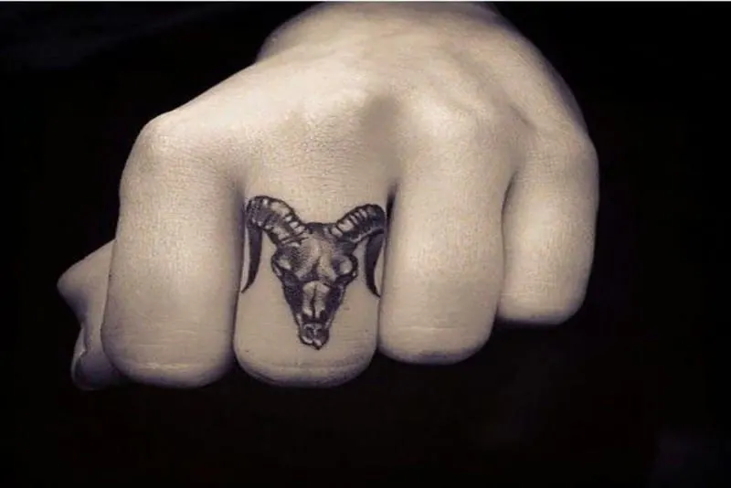 Aries ram skull tattoo on a finger