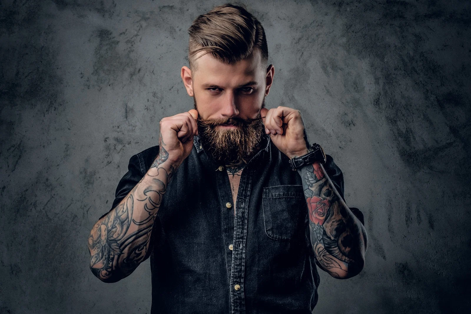 bearded hipster with tattooe on his arms