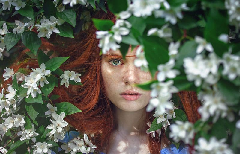 il bel viso nascosto e ricoperto di piccoli fiori e foglie bianche