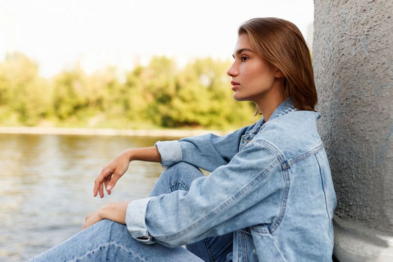 beautiful woman sitting by the river