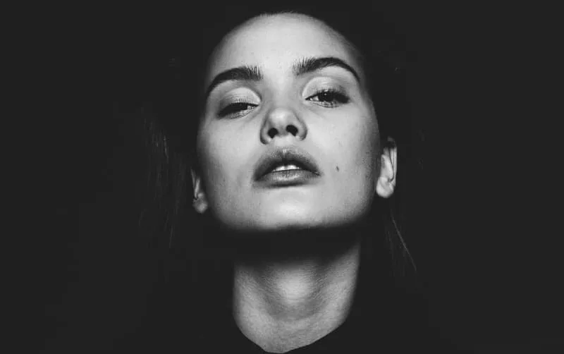 Black and white closeup portrait of a woman looking upward