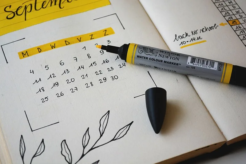 black marker on notebook with calendar on it