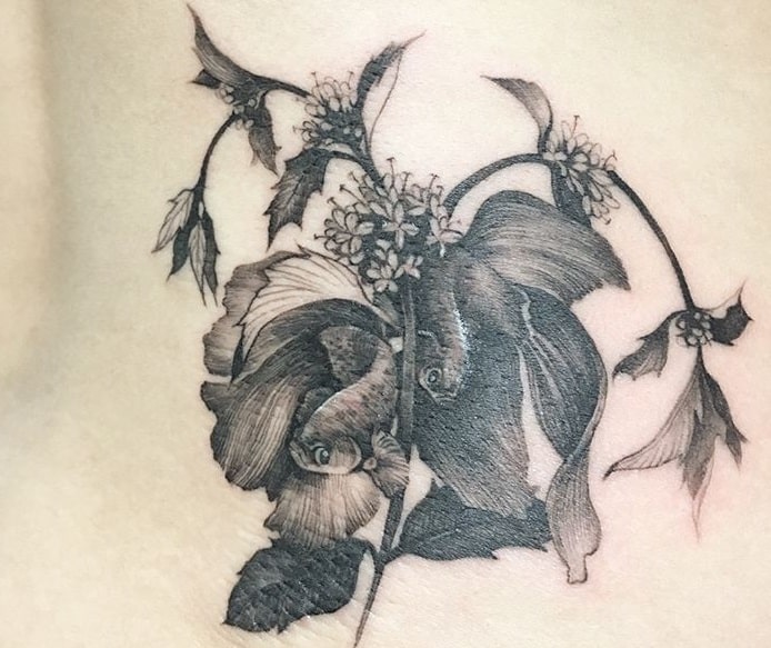 black pisces tattoo between a flower