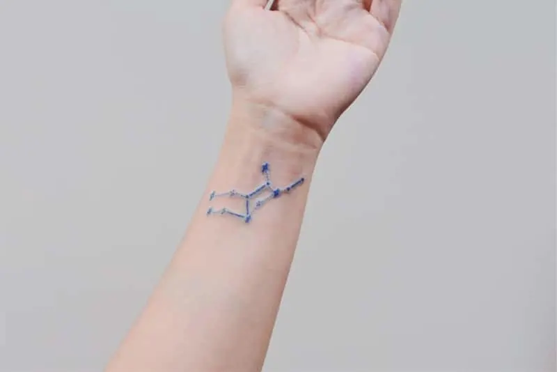 blue Virgo constellation tattoo on the wrist