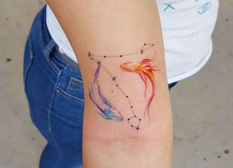 blue and orange pisces tattoo with the constellation