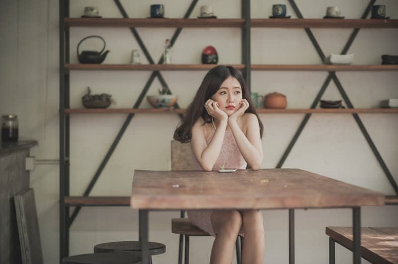 mujer aburrida sentada escuchando con auriculares