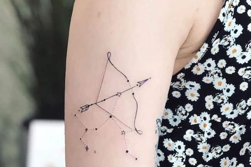 bow and arrow with sagittarius constellation tattoo on the shoulder