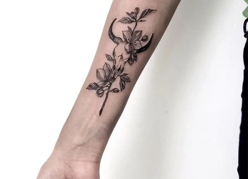 bull scull tattoo with flowers on the wrist