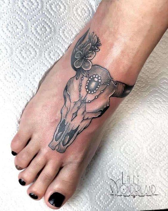 tatuaggio con teschio di toro sul piede