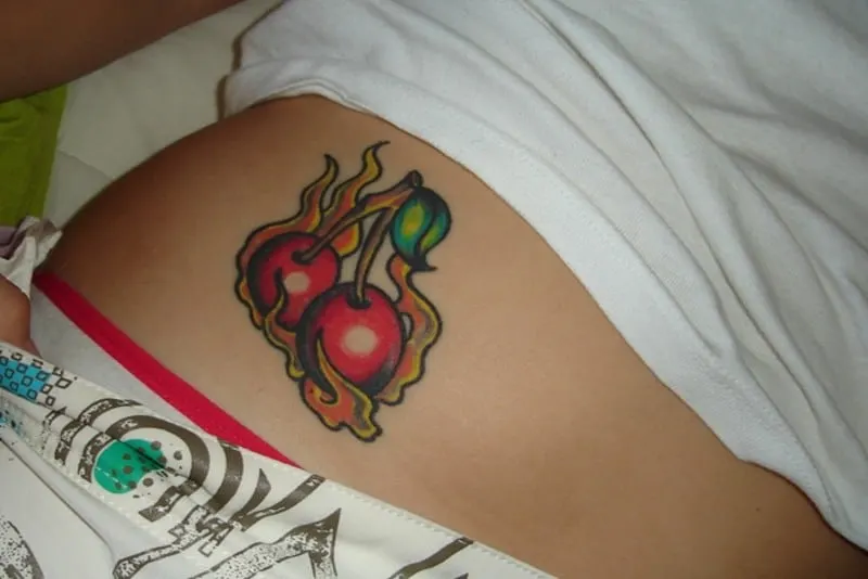 burning cherry tattoo on hip